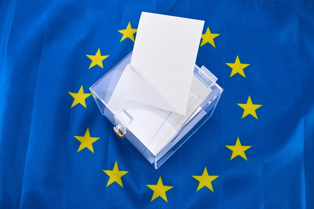 wybory do Parlamentu Europejskiego 2024 zwizualizowane w postaci urny, karty do głosowania i flagi unii europejskiej